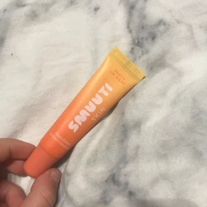 Smuuti Skin Peach Lip Mask - Näringsrik läppmask med persikaextrakt och ceramider som vårdar och återfuktar torra läppar. Vegansk och designad i Finland, tillverkad i Korea. Perfekt för att ge läpparna extra vård och fukt.
