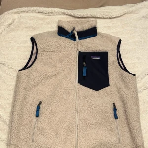 Patagonia Väst - Tja, säljer nu denna feta väst från Patagonia. Västen har blivit lite liten och därför vill jag bli av med den. Toppskick och inga defekter. Den är i storlek M men skulle säga att den passar S bättre.