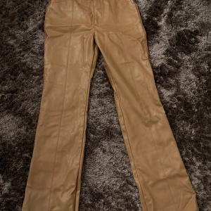 Bruna skinnbyxor (faux leather)  - Snygga bruna skinnbyxor mid-Waist och raka ben. 