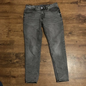 Grå jeansbyxor - Snygga grå jeansbyxor med en klassisk femficksdesign och knappgylf. De har en straight passform som ger en tidlös look. Perfekta för en avslappnad stil.