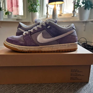 Nike Sb Dunk, Lilac  - Skorna är i väldigt bra skick då de bara är använda några fåtal gånger. Sedan har de bara stått på hyllan. Storleken är bra o h kvitto finns. Medföljer 2 snören. De har ett nypris på cirka 4500 kr