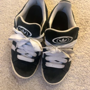 Svarta Adidas Campus sneakers - Säljer ett par Adidas Campus skor i storlek 37 och en tredje del, dem är använda men bra sick då de inte finns defekter bara liksom smuts som man kan tvätta bort . Har även svarta snören till!  Hör av vid frågor !💕