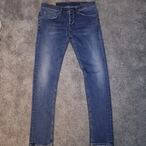 Blå jeans från Dondup - Snygga blå jeans från Dondup med klassisk femficksdesign och knappgylf. De har en straight passform och är perfekta för en avslappnad stil. Märkesdetalj på baksidan av midjan.