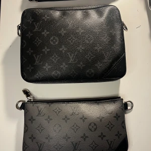 Svart axelväska med monogram - Snygg svart axelväska med monogrammönster. väskan är jätte snygg och stilren den ända defekten är att mobogrammet har suddats ut lite på ett ställe du ser på de sista bilderna