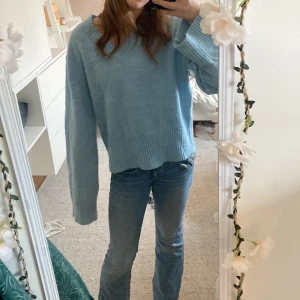 Ljusblå stickad tröja från Gina Tricot - Säljer en ljusblå stickad tröja från Gina Tricot. Tröjan har en v-ringad design och långa ärmar med ribbade muddar. Perfekt för kyligare dagar och ger en mysig känsla. Passar bra till jeans eller kjol för en avslappnad look. Den är lite oversised men skit snygg🥰😍