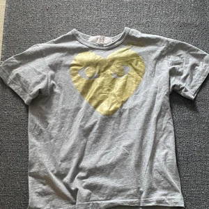 Comme des Garçons PLAY T-Shirt - Tröjan är i jättebra skick! Är i storlek L men det här märket är ju ganska litet så sitter nog som M för Män.