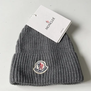 Moncler mössa  - Mössan är one size så passar alla. Den är helt ny och aldrig använd perfekt för dig som vill ha en snygg mössa till vintern!
