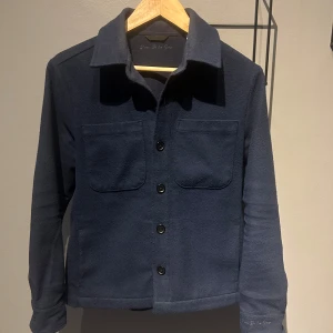 d'once de la sense overshirt - Säljer denna riktigt snygga overshirt från märket d'once de la sense i stl xxs men den passar runt 170cm. Den är i bra skick. Något med ljuset gör att färgen skiftar lite i bilden men det syns inte i verkligheten. Kan skicka fler bilder om det hehövs