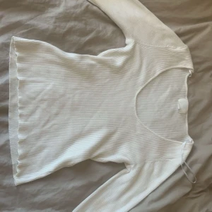 Vit ribbad tröja - Säljer en superfin vit ribbad tröja med långärmad design. Den har en v-ringad hals och är perfekt för både vardag och fest. Tröjan är i bra skick och passar till det mesta i garderoben!
