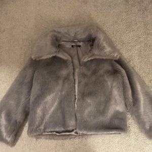 Päls jacka grå - En jätte fin pälsjacka som är köpt från Gina Tricot för några år sedan därav går den ej att köpa längre. Använd väl och har inga deffekter. Jätte bra inför hösten och är i storlek M men passar Xs-M!