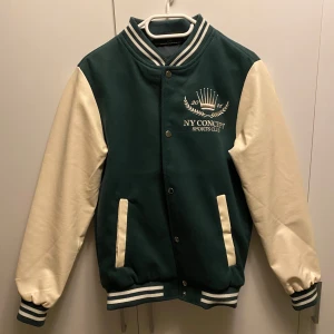 College jacka - Riktigt fin college jacka i storlek Xs men kan passa S. Läder material i armarna och insydd text på ryggen. Väldigt bra kvalite och passar perfekt att ha som overshirt. Endast använd enstaka gånger så helt utmärkt skick.