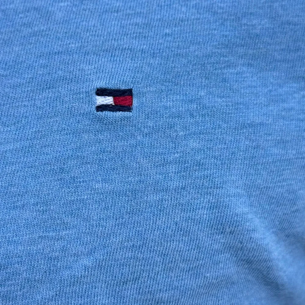 Säljer en snygg blå t-shirt från Tommy Hilfiger i storlek 152. Den är gjord av ekologisk bomull och har en liten broderad logga på bröstet. Perfekt för en avslappnad stil! Skick 8/10. T-shirts.