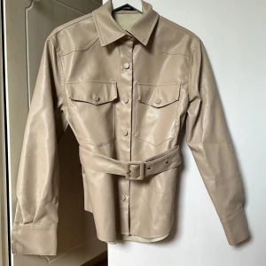 Läderjacka beige - Säljer denna fina beiga läderjacka från BOOHOO som aldrig kommit till användning. Jättefin till hösten🍂 Skriv vid funderingar💞