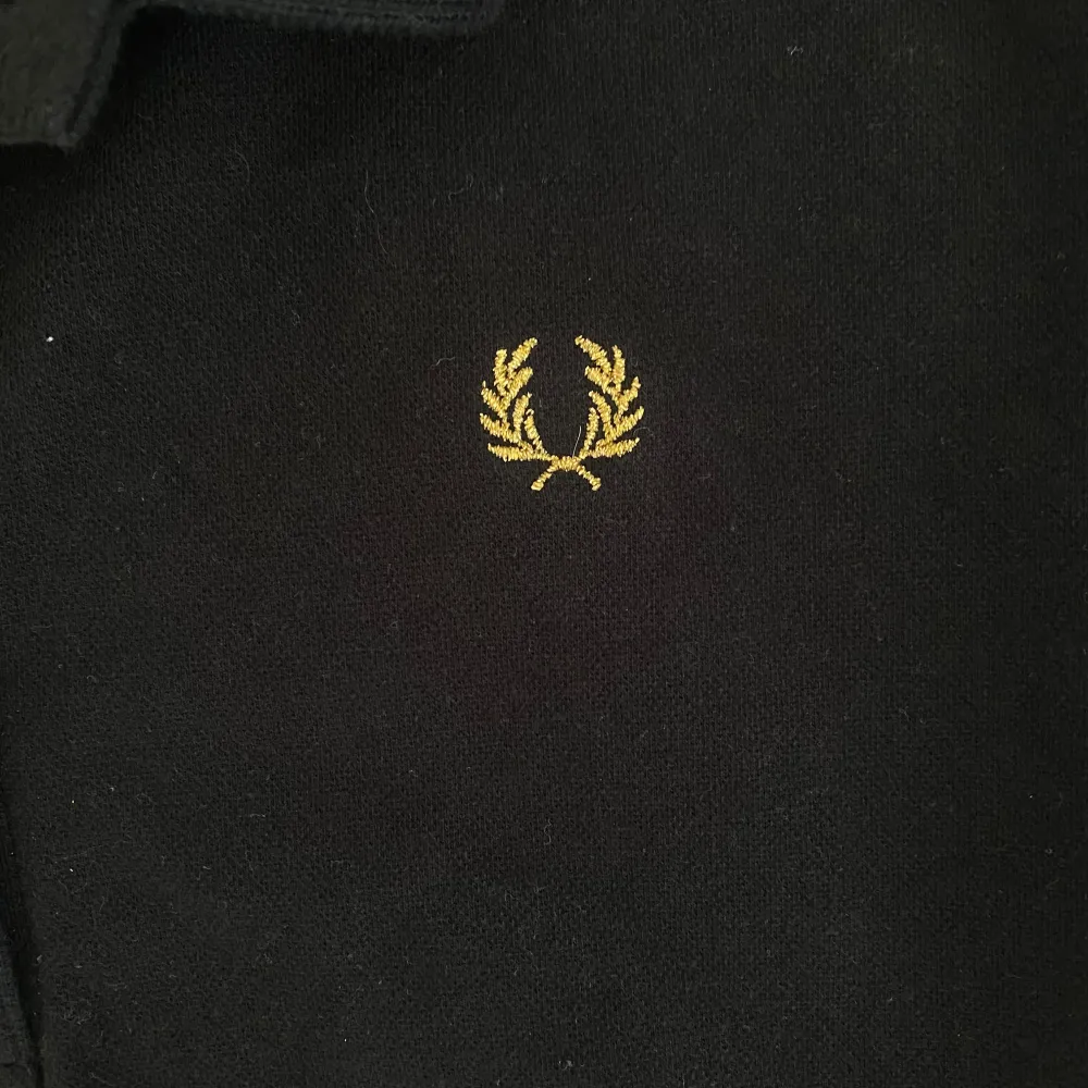 Säljer en svart Fred Perry t-shirt med guldiga detaljer på armarna och kragen. Väldigt bra skick endast använd fåtal gånger. Står stolek 44 men passar mer som en M/38. Jag brukar ha S/M i toppar💗☺️. Toppar.