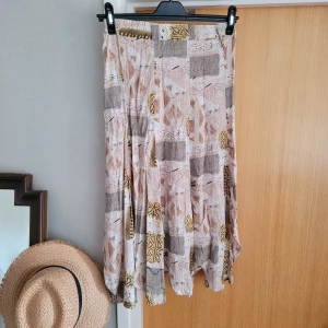 Vintage kjol - Sladdrig och sval. Med öglor att sätta skärp eller så i. Står ingen storlek i men resår i midjan, uppskattninsvis XS-M