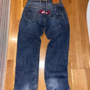 Vintage Evisu Jeans  - Ett par äldre evisu jeans med tag  Tagen saknar en knapp, påverkar inte hur jeansen ser ut så mycket men går att fixa 