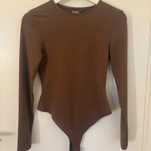 Brun långärmad topp från Bianca x Nelly.com - Säljer en brun långärmad body från Bianca x Nelly.com. Perfekt för hösten! 