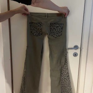 Lågmidjade jeans - Lågmidjade leopard jeans! Köpte dom begagnat och dom är egensydda. Ljusbruna/grå.