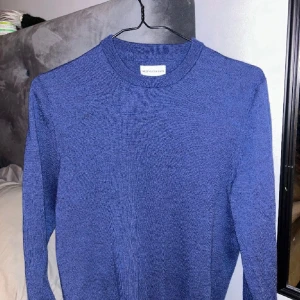 Blå merinoulltröja från These Glory Days - Säljer en snygg blå tröja från These Glory Days i Superior Merino. Perfekt för kyliga dagar med sin mjuka och varma känsla. Tröjan har en klassisk design med rund hals och långa ärmar. Passar både till vardags och lite finare tillfällen. 🧶💙