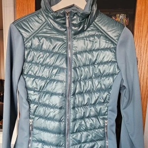 Equestrian stockholm jacka nytt - Finns inte att köpa denna färg längre. Tyvärr bara legat nedpackad Lyxig multifunktionell jacka i en sportig och elegant design med grå,blå turkos och kromdetaljer. Framsidan och baksidan är gjorda med ett glansigt och slitstarkt tyg med metallisk finish. 