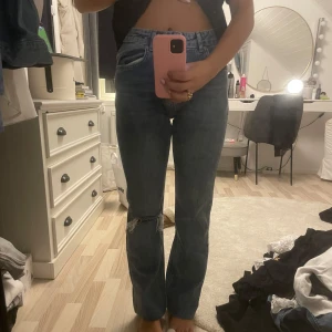 Blå jeans från g perfect jeans - Säljer ett par snygga blå jeans från gina tricot (perfect jeans) i storlek 36. De har en straight passform och är högmidjade. Jeansen har slitna detaljer vid knäna och en mörkblå färg, dom är uppsydda ca 10 cm men går att sprätta upp❤️❤️ Är 167 cm