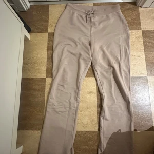 Beige mjukisbyxor med snörning - Säljer ett par superbekväma beige mjukisbyxor. De har en skön passform med snörning i midjan för justerbarhet. Perfekta för en avslappnad dag hemma eller en snabb tur till affären. 