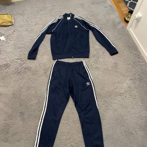 Mörkblå adidas sst Tracksuit, knappt använd jätte bra skick, säljs pga den är stor. Koftan är stl M och byxorna är S