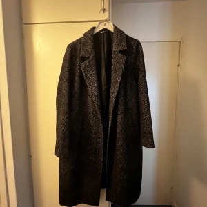 Svart och vit rock från XLNT - Säljer en stilren svart och vit rock från XLNT i storlek 2XL. Rocken har ett fint mönster och är perfekt för höst/vinter. Den är långärmad och har en elegant passform. Använd endast ett fåtal gånger, i nyskick! Pris kan diskuteras