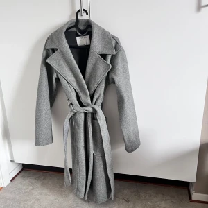 Lång kappa - Grå elegant kappa <3 Superfin nu till hösten. Tyvärr var den aningen för stor för mig och säljer den nu vidare <3  Det är storlek S, Pris kan diskuteras!