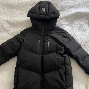 Sail Racing vinterjacka - Sail Racing Patrol Down jacket i storlek 170. Varm vinterjacka i bra skick som har använts i ungefär 1,5 vinter. Tyvärr är hängaren sönder men går att fixa ganska lätt 😁