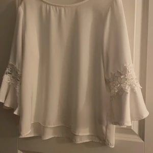 Söt blus  - En vit och stilren blus, trekvartsärm med brodyr och lös form.  Något smal i ärmarna, men sitter väldigt fint