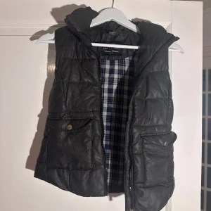 Tjejväst från HM - Svart tjejväst med fickor framtill, liten upprepning inne i västen som finns på bilden. Stl 148 Zarakids