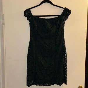 Mörkgrön spetsklänning - Säljer en elegant mörkgrön spetsklänning i storlek M. Klänningen har en vacker spetsdesign och är perfekt för festliga tillfällen. Den är kort och har en klassisk stil som passar både höst och vår. Perfekt för dig som vill ha något stilrent och tidlöst!
