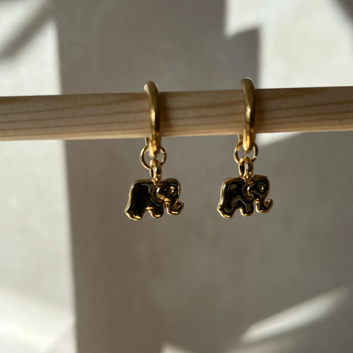 Guldörhängen med elefantberlocker