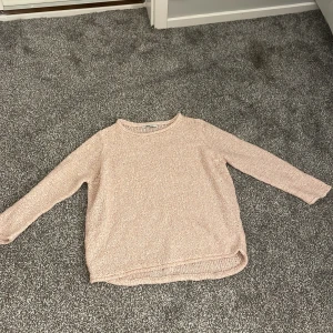 Ljusrosa stickad tröja från Gina Tricot - Mysig ljusrosa stickad tröja från Gina Tricot. Tröjan har en enkel design med långa ärmar och rund halsringning. Perfekt till ett vitt linne eller liknande!