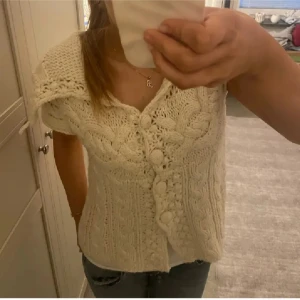 Vit stickad kofta från KappAhl - Säljer en mysig vit stickad kofta från KappAhl med vackra flätmönster och knappar framtill. Koftan har korta ärmar och en unik design som ger en stilren look. Vill påpeka att dom två första bilderna är lånade!!!