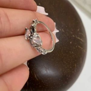 Silverring med stenar från Pandora - Elegant silverring från Pandora dekorerad med flera klara stenar i olika former. Perfekt för att ge en glittrig touch till din stil. Ringen har en vacker design som fångar ljuset fint.