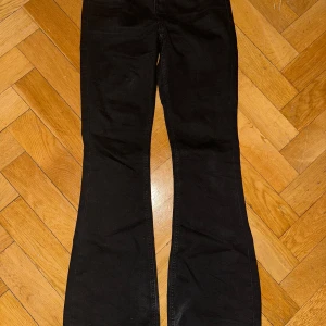 Svarta bootcut byxor - Snygga svarta bootcut byxor med hög midja. Perfekta för en stilren look. Byxorna har en klassisk design med fickor bak och en bekväm passform.