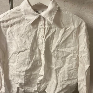 Linne shorta  - Säljer en klassisk vit skjorta från Zara i bomull. Skjortan har en traditionell krage och knappar framtill. Perfekt för en stilren look. Kan styckas innan jag skickar.