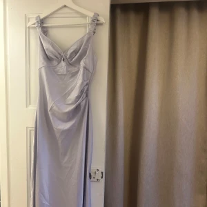 Ljuslila långklänning från ADOORE - Elegant ljuslila långklänning från ADOORE med smickrande drapering och smala axelband. Aldrig använd. Något felsydd framtill, därav sänkt pris. 