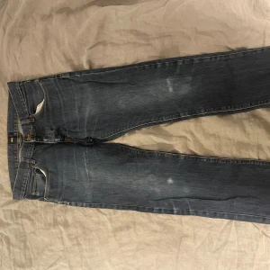 Blå jeans från ASOS - Snygga blå jeans från ASOS med klassisk femficksdesign och dragkedja. De har en normal passform och är perfekta för en avslappnad stil. Midjan är w32 och de har en stilren look med lätt slitna detaljer.