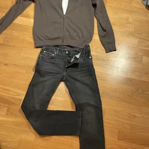 Tommy hilfiger jeans - 10/10 skick. Helt nya och med en snygg grå-vit tvätt över det svarta. Jeansen är i den populära slim/straight passformen. Ny pris 1200 kr