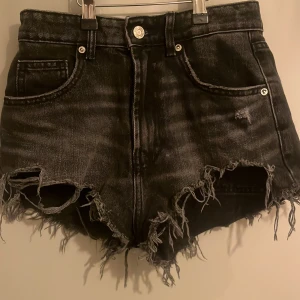 Svarta jeansshorts från Zara - Säljer ett par coola gråa jeansshorts från Zara med slitna detaljer och fransig kant. Perfekt nu till sommaren 💕