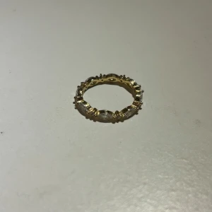 Guldfärgad ring med stenar - Elegant guldfärgad ring dekorerad med klara stenar runt om.⭐️ Passar bra till både vardag och speciella tillfällen.
