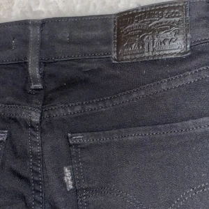 Svarta bootcut jeans från Levi's - Aldrig använda då jag fick dom i julklappspresent men dom passade inte och returtiden hade tagit slut. Snygga svarta bootcut jeans från Levi's, modell 715. Perfekta för en stilren look med klassisk passform. Tillverkade i ett slitstarkt material som ger en bekväm känsla hela dagen. 