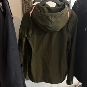 Exklusiv Grön vindjacka från Moncler (St M) - Sätt stilen med denna eftertraktade Moncler windbreaker! Självklart äkta. Lätt, stilren och perfekt för alla väder. Den trendiga gröna färgen och ikoniska passformen i storlek M gör den till ett måste. Hög efterfrågan – sno den innan någon annan gör det! perfekt för alla väder, från blåsiga vårdagar till svala sommarkvällar. Är även öppen för byten och kom med prisförslag! Tveka inte på att höra av dig vid intresse.