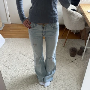 Lågmidjade ljusblå jeans med slitningar - Jättesnygga lågmidjade utsvängda  ljusblå jeans med slitningar!!💗💗