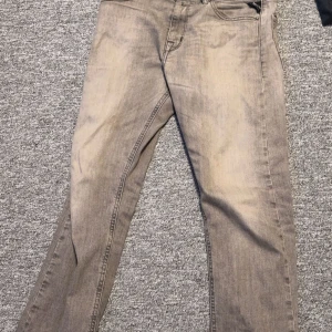 Grå jeans från Replay - Snygga grå jeans från Replay skick 8/10, med en klassisk femficksdesign. De har en straight passform och är perfekta för en avslappnad stil. Märkesdetaljer på baksidan ger en extra touch. Taggen där bak är ganska sliten men inget man tänker på. Modellen är 177 och väger ca 55 kilo. Hör av er vid funderingar 
