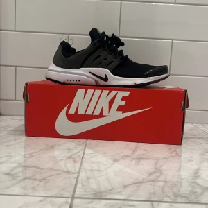 Nike Air Presto i svart och grå - Snygga Nike Air Presto sneakers i svart och grått med vit sula. Skorna har en modern design med snörning och är perfekta för en sportig look. De är välldigt sparsamt andvända de är som nya oxh har andvända 4-5 gånger. Hör av er vid minsta frågan.