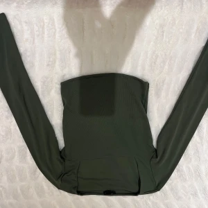 Grön topp - Snygg grön  topp med långa ärmar. Perfekt för en stilren look. Toppen har en tight passform och är tillverkad i ett mjukt material.